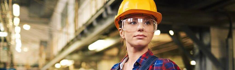 worker in factory wearing glasses and helmet